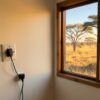 Prise Afrique du Sud : adaptateur de voyage branché sur une prise murale à trois gros trous ronds dans une chambre de lodge