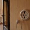 Prise Égypte : chargeur branché sur une prise murale à deux trous ronds dans une chambre d'hôtel ouverte sur le Nil