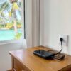 Prise île Maurice : chargeur de téléphone branché à une prise murale d'une chambre d'hôtel avec vue sur le lagon