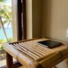 Prise Philippines : smartphone en charge sur une table de chevet en bambou dans un bungalow de plage, adaptateur de voyage branché au mur