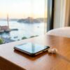 Prise Turquie : téléphone et écouteurs en charge sur une table de chevet d'hôtel à Istanbul, vue sur le Bosphore au coucher du soleil